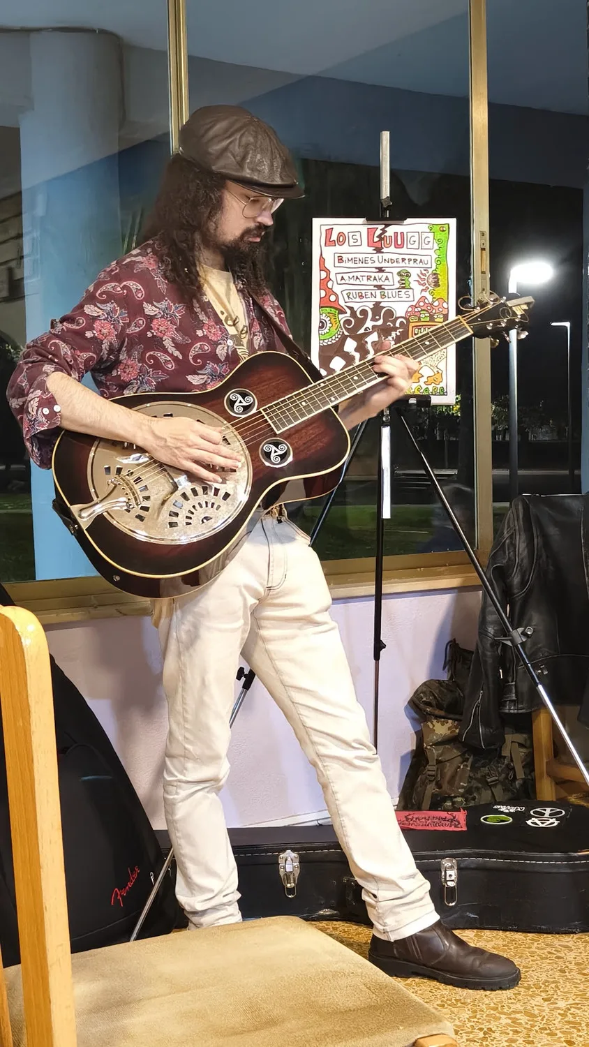 Músico con guitarra resonadora durante el concierto
